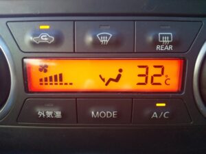 車内のエアコンを操作している人の画像