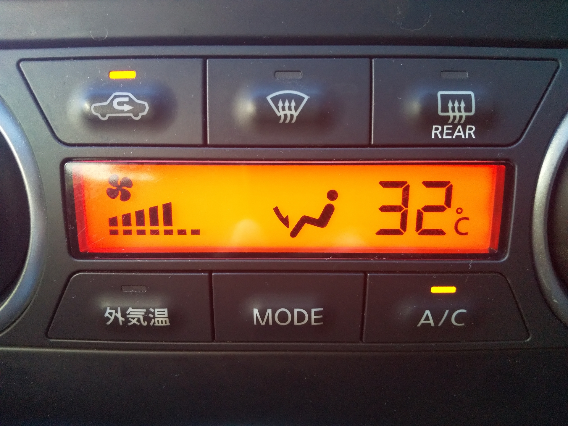 車内のエアコンを操作している人の画像