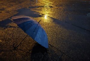 雨の日に使用した傘を手入れしている人の画像